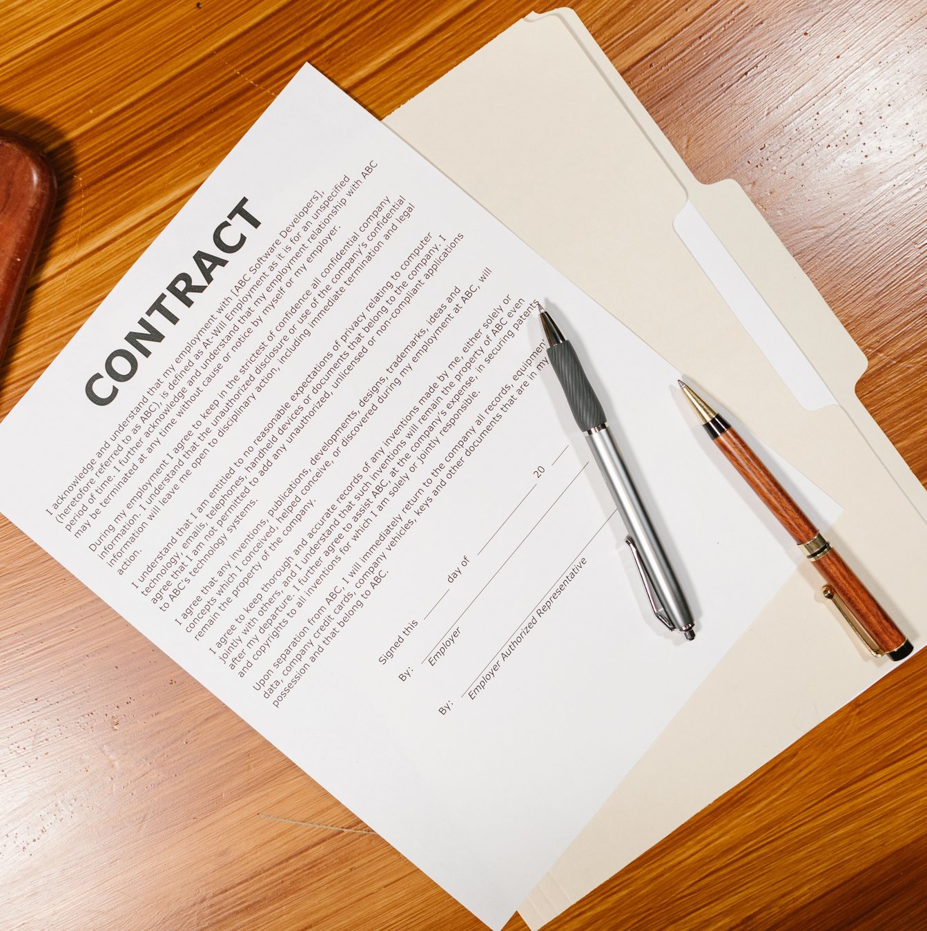 Contract with pens on a wooden desk